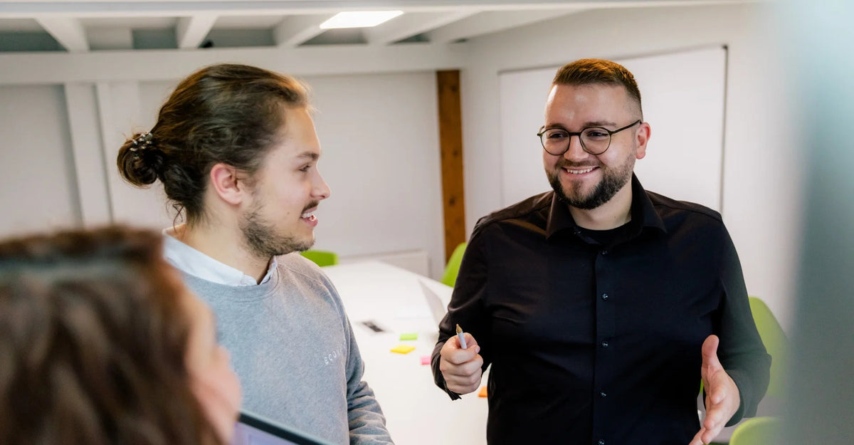 Drei Teammitglieder im Gespraech waehrend einer Beratung